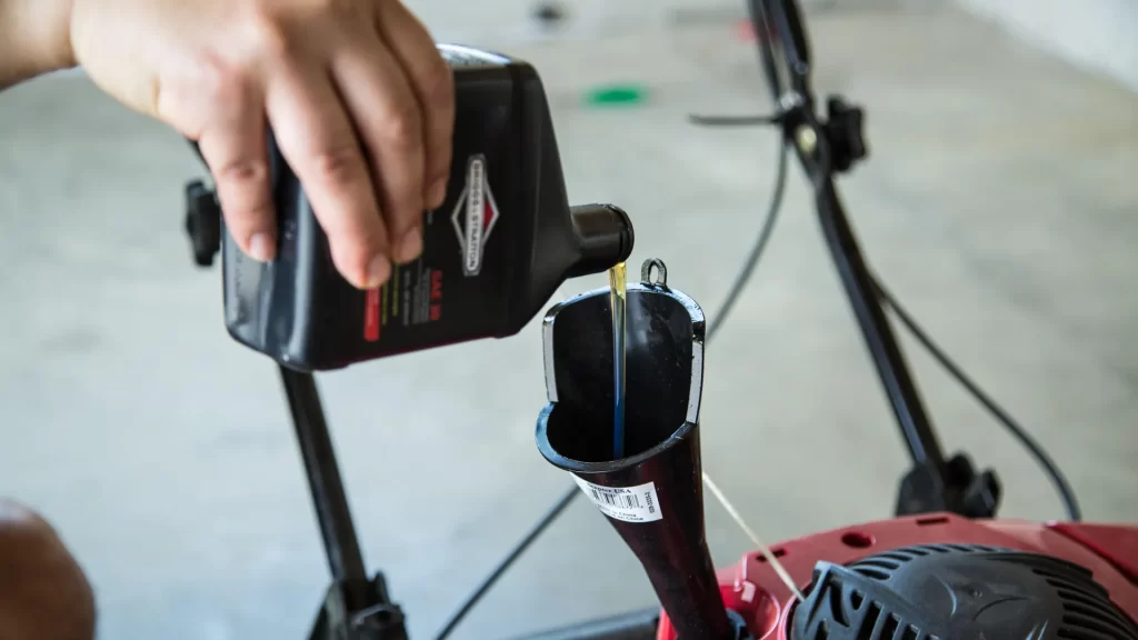 Pouring engine oil in a lawn mower