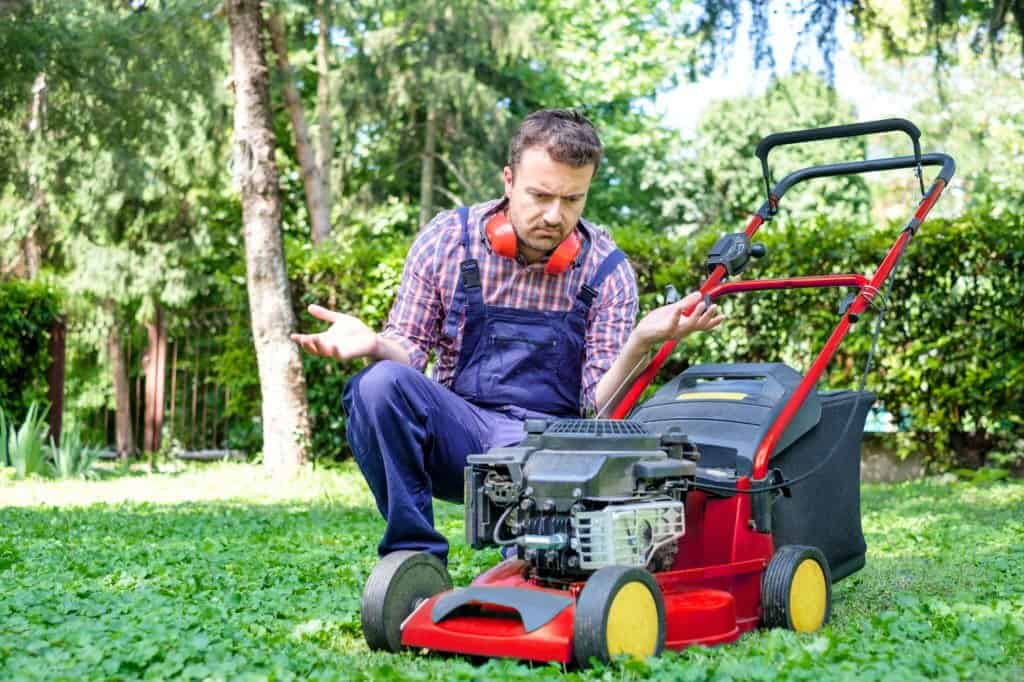 man with lawnmower having problems
