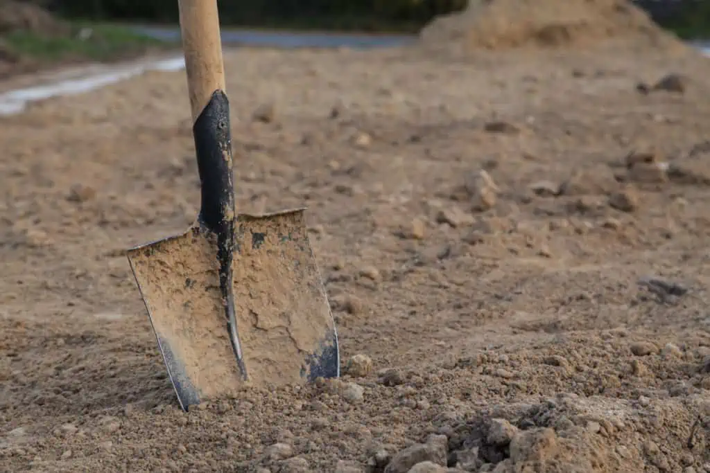 closeup spade in dry clay soil