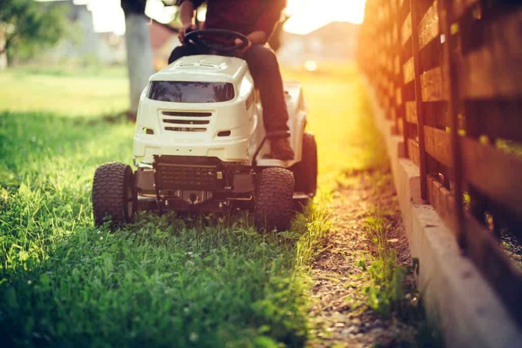 Worker riding industrial lawnmower