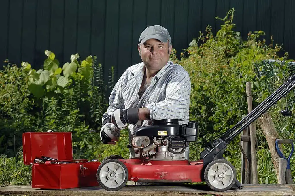 man fixing or tuning-up a lawnmower